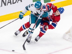 San Jose Sharks' Mario Ferraro holds off Montreal Canadiens' Juraj Slafkovsky during the first period of a National Hockey League game in Montreal Thursday Jan. 11, 2024.