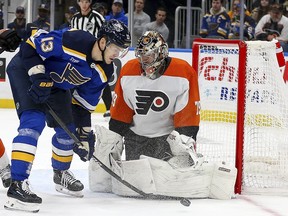 St. Louis Blues' Alexey Toropchenko reaches for the puck as Philadelphia Flyers goaltender Carter Hart defends.