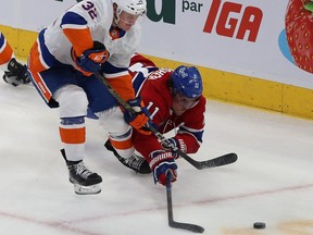 Canadiens' Brendan Gallagher dives toward the puck while battling with Islanders defenceman Adam Pelech during second period Thursday night at the Bell Centre. One period later, Gallagher laid out Pelech with a dirty hit.