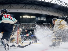 Zach Whitecloud #2 of the Vegas Golden Knights skates against Matty Beniers #10 of the Seattle Kraken as Logan Thompson #36 tends net during the third period at T-Mobile Park on January 01, 2024 in Seattle, Washington.