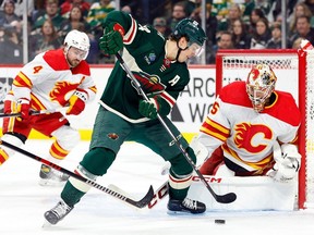 ST PAUL, MINNESOTA - JANUARY 02: Jacob Markstrom #25 of the Calgary Flames defends the net against Joel Eriksson Ek #14 of the Minnesota Wild in the first period at Xcel Energy Center on January 02, 2024 in St Paul, Minnesota.