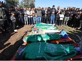 Mourners recite a prayer over the flag-draped bodies of Palestinians killed during an Israeli raid in Jenin in the occupied West Bank, during their funeral on January 7, 2024.