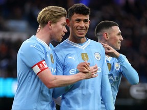 Kevin De Bruyne and Matheus Nunes of Manchester City celebrate after teammate Jeremy Doku (not pictured) scores their team's fifth goal during the Emirates FA Cup Third Round match between Manchester City and Huddersfield Town at Etihad Stadium on January 07, 2024 in Manchester, England.