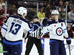Mark Scheifele (55) of the Winnipeg Jets celebrates with teammate Gabriel Vilardi (13) after scoring an empty net goal against the Arizona Coyotes during the third period at Mullett Arena on Jan. 7, 2024 in Tempe, Ariz.