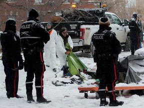 Police and city crews remove garbage, but leave occupied tents alone at a homeless encampment near 95 Street and 101A Avenue, in Edmonton Tuesday Jan. 9, 2024. Residents refused to leave when police and city crews arrived Tuesday morning to remove the encampment.