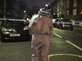 Police inspect the scene of an incident near Clapham Common, London, after a suspected corrosive substance was thrown at a woman and her two young children Wednesday Jan. 31, 2024.