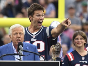Former New England Patriots quarterback Tom Brady points toward the audience as Patriots owner Robert Kraft, left, addresses the crowd and Brady's daughter Vivian, right, looks on during halftime ceremonies held to honour Brady at an NFL football game between the Philadelphia Eagles and the Patriots on Sunday, Sept. 10, 2023, in Foxborough, Mass.