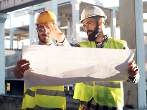 Two engineers working on building site together