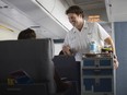 Steward serving passengers on airplane