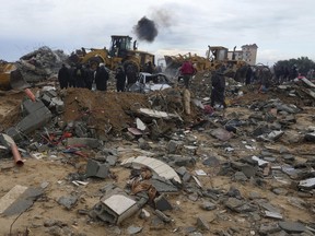 Palestinians search for bodies after an Israeli strike in Zuweida, Gaza Strip, Monday, Jan. 29, 2024.