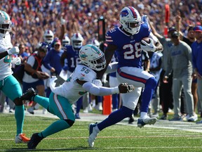 Latavius Murray, left, of the Buffalo Bills runs the ball as Jerome Baker of the Miami Dolphins makes the tackle during the first quarter at Highmark Stadium on Oct. 1, 2023 in Orchard Park, N.Y.