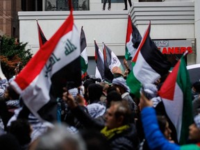 Demonstrators in support of Palestinians wave Palestinian flags during a protest in Toronto, Oct. 9, 2023.