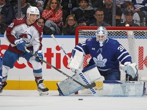Avalanche forward Ross Colton, left, looks to tip a shot against Maple Leafs goalie Martin Jones during second period NHL action at Scotiabank Arena in Toronto, Saturday, Jan. 13, 2024.