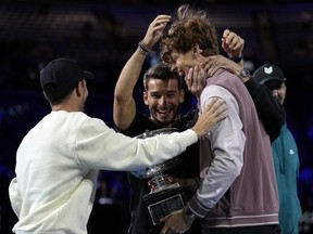 Jannik Sinner of Italy is congratulated by his support team after receiving the Norman Brookes Challenge Cup after defeating Daniil Medvedev of Russia in the men's singles final at the Australian Open tennis championships at Melbourne Park, in Melbourne, Australia, Sunday, Jan. 28, 2024.