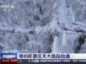 In this image taken from video footage run by China's CCTV, excavators clear a road blocked by snow in Altay Prefecture in northwestern China's Xinjiang Uyghur Autonomous Region on Tuesday, Jan. 16, 2024.