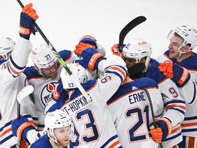 Edmonton Oilers players celebrate a goal by teammate Evan Bouchard against the Montreal Canadiens during overtime period NHL hockey action in Montreal, Saturday, Jan. 13, 2024.