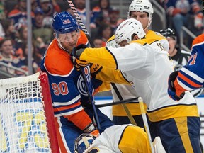 Corey Perry of the Edmonton Oilers, is pushed out of the crease by Luke Schenn(2) of the Nashville Predators at Rogers Place in Edmonton on Jan.27, 2024.