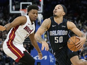 Orlando Magic guard Cole Anthony (50) drives around Miami Heat guard Kyle Lowry, left, during the second half of an NBA basketball game Sunday, Jan. 21, 2024, in Orlando, Fla.