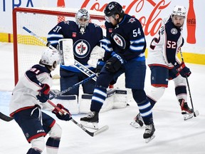 Winnipeg Jets' goaltender Connor Hellebuyck (37) makes a save on a shot by Columbus Blue Jackets' Kent Johnson (91) during the first period of NHL action in Winnipeg on Tuesday Jan. 9, 2024.