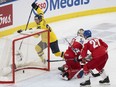 Sweden's Otto Stenberg (25) celebrates a goal by teammate Sweden's Theo Lindstein (not shown) in front of Czechia goaltender Michael Hrabal (30) and Marek Alscher (27) during first period semifinal hockey action at the IIHF World Junior Hockey Championship in Gothenburg, Sweden, Thursday Jan. 4, 2024.