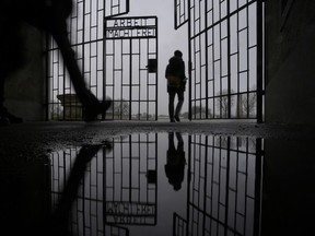 A person enters the Sachsenhausen Nazi death camp through the gate with the phrase "Arbeit macht frei" (work sets you free) in Oranienburg, Germany, on Jan. 25, 2022.