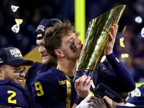 J.J. McCarthy of the Michigan Wolverines kisses the national championship trophy after defeating the Washington Huskies at NRG Stadium on January 8, 2024 in Houston.