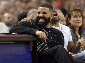 Performer Drake has a laugh courtside during NBA action between the Toronto Raptors and the Milwaukee Bucks, in Toronto, Tuesday, Feb. 25, 2020.