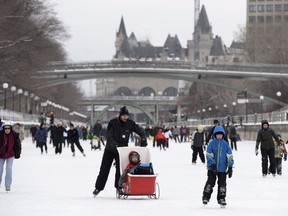 The Chateau Laurier is seen behind skaters on the Rideau Canal Skateway at the Winterlude Festival in Ottawa, Saturday, Jan. 30, 2016.
