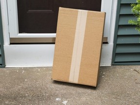 A package is delivered at the front door of a residential house out in the open.