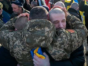 This handout photograph taken and released on January 31, 2024 by the Ukrainian Presidential Press Service, shows Ukrainian former prisoners of war reacting following a prisoner exchange.