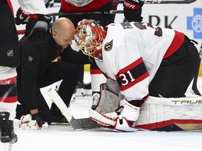 Senators goaltender Anton Forsberg (31) talks with a trainer after being injured in the first period of Thursday's game at Buffalo.