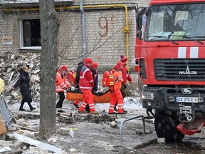Medical staff carry a local resident injured in a missile attack in Kharkiv on January 23, 2024.