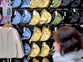 A woman walks past a display of bags at a Uniqlo retail store in Tokyo on Jan. 16, 2024.