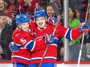 Canadiens's Alex Newhook, left, congratulates Arber Xhekaj after the defenceman scored the opening goal Wednesday night against the Sabres at the Bell Centre.