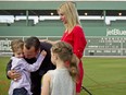 Boston Red Sox pitcher Tim Wakefield hugs his son, Trevor, 7, as his wife, Stacy, right, and daughter, Brianna, 6, look on after Wakefield announced his retirement in 2012.
