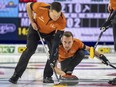 Ben Hebert sweeps as skip Brendan Bottcher delivers a rock during the 2023 Brier.