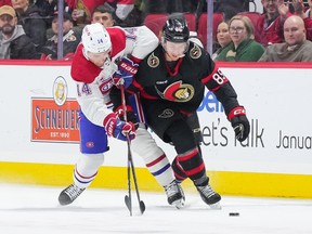 Nick Suzuki #14 of the Montreal Canadiens and Jake Sanderson #85 of the Ottawa Senators battle for the puck during the first period at Canadian Tire Centre on Jan. 18, 2024 in Ottawa, Ontario, Canada.