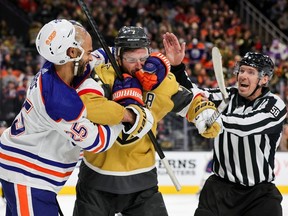 Darnell Nurse of the Edmonton Oilers and Alex Pietrangelo of the Vegas Golden Knights scuffle as linesman Ryan Gibbons moves in to break them up in the second period of their game at T-Mobile Arena on Tuesday.