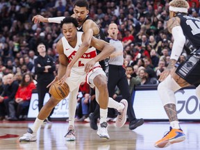 Victor Wembanyama, back, of the San Antonio Spurs tries to strip the ball from Scottie Barnes of the Toronto Raptors in the first half of their NBA game at Scotiabank Arena on Monday, Feb. 12, 2024, in Toronto.