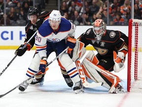 Ilya Lyubushkin #46 and Lukas Dostal #1 of the Anaheim Ducks defend against Corey Perry #90 of the Edmonton Oilers during the third period of a game at Honda Center on February 09, 2024 in Anaheim, California.