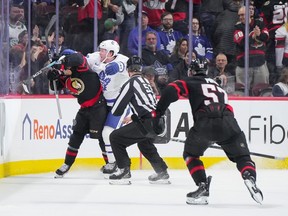 Morgan Rielly #44 of the Toronto Maple Leafs cross checks Ridly Greig #71 of the Ottawa Senators in the head after his empty net goal in the third period at Canadian Tire Centre on February 10, 2024 in Ottawa, Ontario, Canada.
