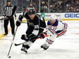 Quinton Byfield #55 of the Los Angeles Kings skates the puck against Mattias Janmark #13 of the Edmonton Oilers in the second period at Crypto.com Arena on February 10, 2024 in Los Angeles, California.