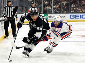 Quinton Byfield #55 of the Los Angeles Kings skates the puck against Mattias Janmark #13 of the Edmonton Oilers in the second period at Crypto.com Arena on February 10, 2024 in Los Angeles, California.