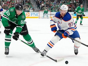 DALLAS, TEXAS - FEBRUARY 17: Thomas Harley #55 of the Dallas Stars is defended by Connor McDavid #97 of the Edmonton Oilers during the first period at American Airlines Center on February 17, 2024 in Dallas, Texas.