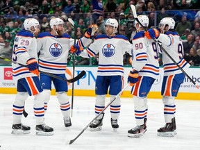 Evan Bouchard (C) #2 of the Edmonton Oilers is congratulated by teammates after scoring a goal during the second period against the Dallas Stars at American Airlines Center on February 17, 2024 in Dallas, Texas.