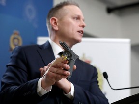 Staff Sgt. Eric Stewart of the Edmonton Police Service guns and gangs section, holds part of a "glock style" 3D printed gun during a news conference, in Edmonton Wednesday Feb. 28. An Edmonton man has been arrested as part of Project Reproduction, a national investigation into privately manufactured firearms (3D printed firearms).