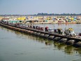 Hindu devotees ride vehicles across a pontoon bridge as they leave after completing one-month stay known as 'Kalpwas' on the banks of Sangam, the confluence of rivers Ganges, Yamuna and mythical Saraswati, during the annual religious 'Magh Mela' festival in Prayagraj on February 24, 2024.