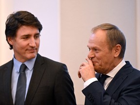Prime Minister Justin Trudeau, left, and Poland's Prime Minister Donald Tusk react during a joint press conference in Warsaw on February 26, 2024. (Photo by SERGEI GAPON/AFP via Getty Images)