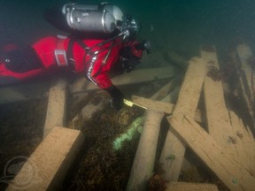 Astern of the Erebus wreck, Parks Canada underwater archaeologist Filippo Ronca measures the muzzle bore diameter of one of two cannons found on the site.