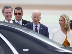 U.S. President Joe Biden (centre) talks with California Governor Gavin Newso (left) and his wife Jennifer Siebel Newsom (right) after arriving at San Francisco International Airport ahead of the APEC summit, Nov. 14, 2023 in San Francisco.